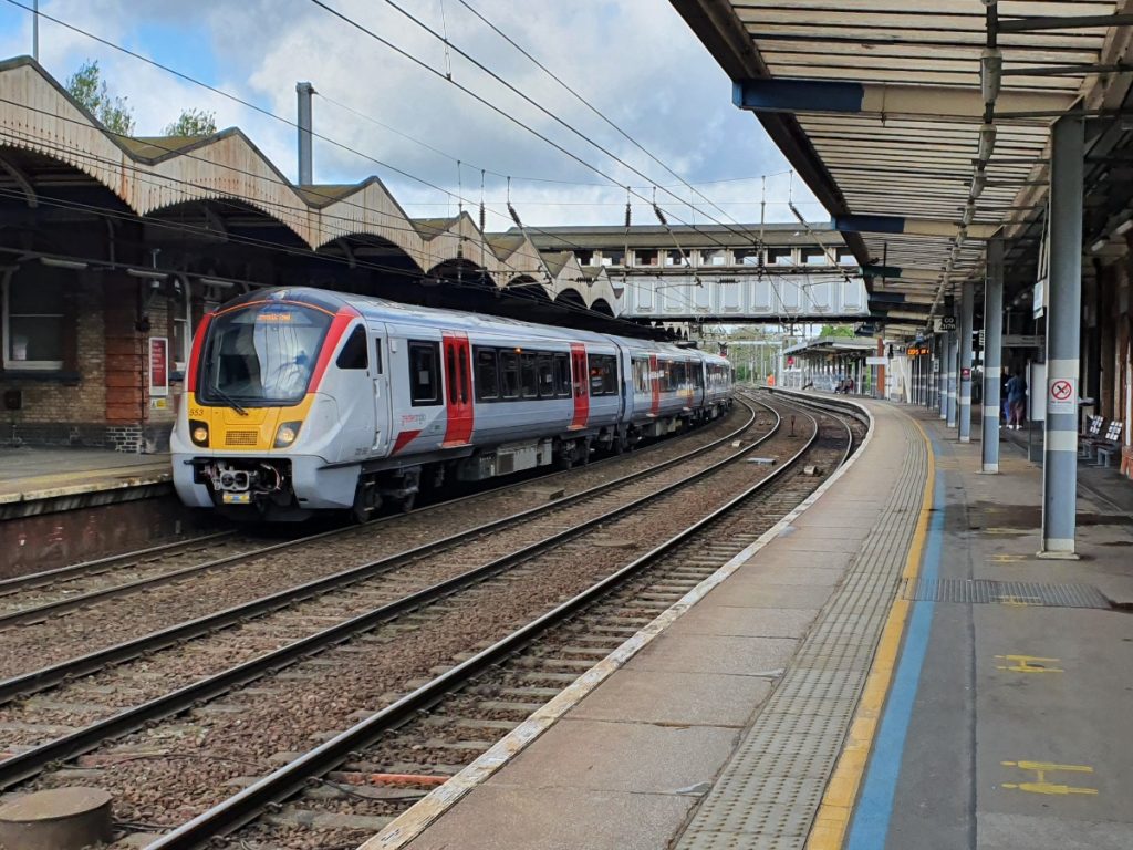 White train with red doors at a train station