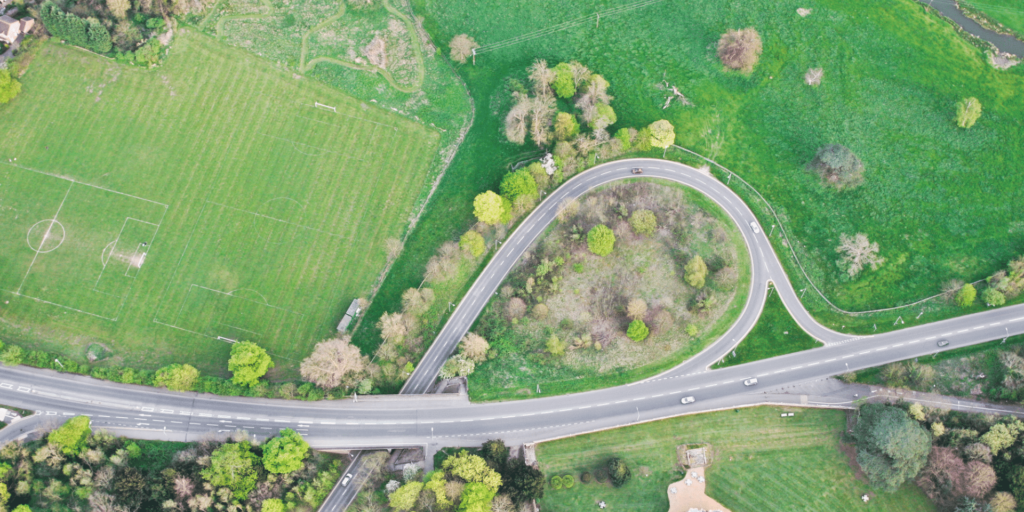Ariel shot of a curved junction off a road surrounded by grass